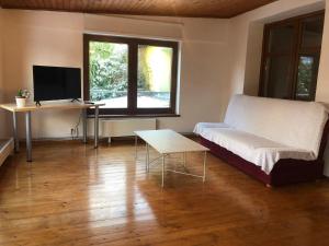 een woonkamer met een bank en een bureau met een computer bij Penzion Apollón in Liberec