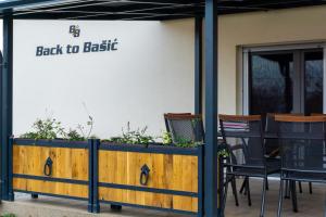 een bord met de tekst 'terug naar de basis' op een gebouw met stoelen bij Kuća za odmor Back to Bašić in Mandičevac
