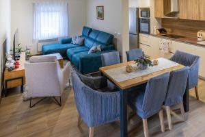 een woonkamer met een tafel en een blauwe bank bij Kuća za odmor Back to Bašić in Mandičevac +28 foto's
