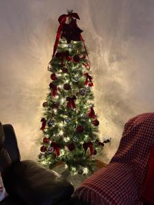 a christmas tree with ornaments in a living room at Katies Cottage in Gortaclare