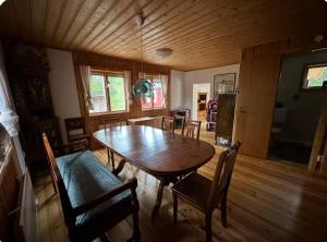 a dining room with a wooden table and chairs at Vilt Hjerte Stugas in Sysslebäck