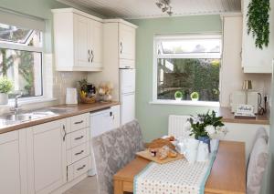 a kitchen with white cabinets and a wooden table at Katies Cottage in Gortaclare +35 photos