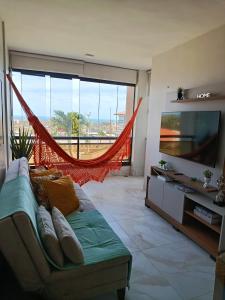 a living room with a couch and a flat screen tv at Marino Beach in Aquiraz