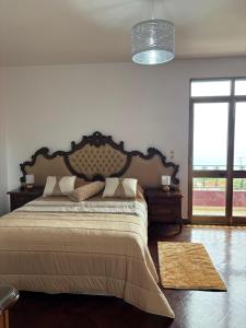 a bedroom with a large bed and a large window at Casa estrelicia II in Relógio do Poiso