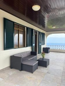 a patio with a couch and a table and chairs at Casa estrelicia II in Relógio do Poiso