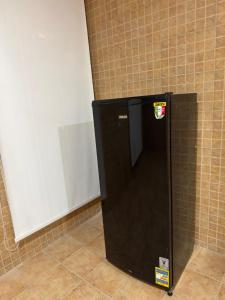 een zwarte koelkast in de hoek van een kamer bij Almajidy Villa in Caïro