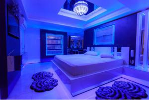 ein Schlafzimmer mit einem großen Bett mit blauer Beleuchtung in der Unterkunft Golden Motel in Passo Fundo