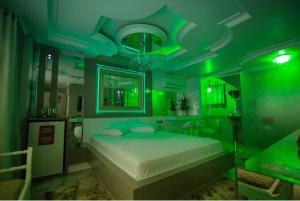 ein grünes Schlafzimmer mit einem Bett und einer grünen Decke in der Unterkunft Golden Motel in Passo Fundo + 1 Foto