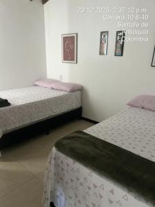 two beds sitting in a room with at Hermoso Apartasol en Santa Fe de Antioquia!!! in Santa Fe de Antioquia +12 photos