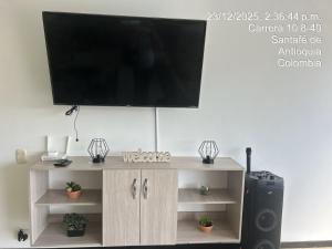 a flat screen tv on top of a wooden entertainment center at Hermoso Apartasol en Santa Fe de Antioquia!!! in Santa Fe de Antioquia