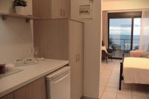 a kitchen with a counter and a dining room with a balcony at Anel Rooms in Himare