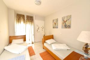 a bedroom with two beds and a window at Oikos in Hanioti +12 photos