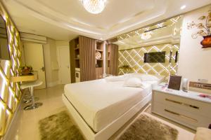 ein Schlafzimmer mit einem großen weißen Bett und einem Schreibtisch in der Unterkunft Golden Motel in Passo Fundo