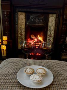 a table with two glasses of wine and a plate of food at Katies Cottage in Gortaclare