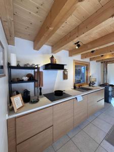 een keuken met houten kasten en een aanrechtblad bij Hüttli Chalet Weitblick 10 Minuten zur Skigondel und Aletschgletscher in Naters