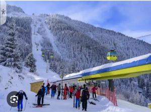 a group of people on a ski slope next to a ski lift at Casa nouă in Vişeu de Sus