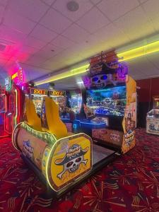 een kamer met twee arcade-spellen in een speelruimte bij Lyon's Robin Hood Rhyl 8 Berth Caravan in Rhyl +23 foto's