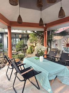 a patio with a table and chairs and a clock at Holly House Mộc Châu in Mộc Châu