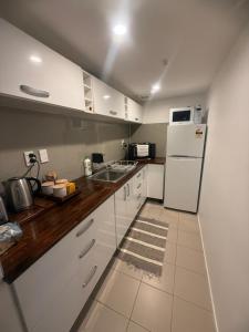 een keuken met witte kasten en een witte koelkast bij The Studio in Whangarei