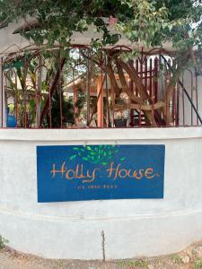 a sign for a holly house in front of a building at Holly House Mộc Châu in Mộc Châu