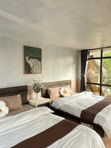 a bedroom with two beds and a zebra picture at Holly House Mộc Châu in Mộc Châu