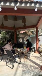 two people sitting at a table in a patio at Holly House Mộc Châu in Mộc Châu