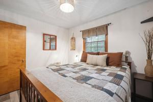ein Schlafzimmer mit einem Bett mit einer Steppdecke darauf in der Unterkunft Cozy Pisgah Cabin w Fire Pit in Newland