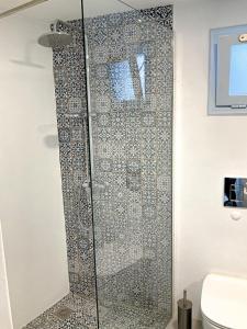 a shower with a glass door in a bathroom at Okeanos in Skiathos Town +26 photos