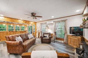 ein Wohnzimmer mit Sofa und Fernseher in der Unterkunft Cozy Pisgah Cabin w Fire Pit in Newland