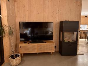 a flat screen tv sitting on a wooden entertainment center at The Wooden House, Spacious, garden, new and modern in Oslo