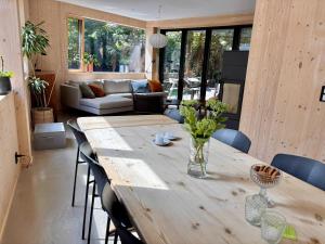a living room with a wooden table and chairs at The Wooden House, Spacious, garden, new and modern in Oslo