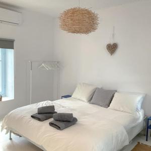 a bedroom with a white bed with two towels on it at Okeanos in Skiathos Town
