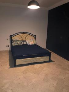 un letto in una camera con struttura nera di Merriem Guest Rooms a Rabat