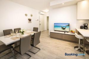 a dining room with a table and a flat screen tv at QUEEN HOME Luana in Venice