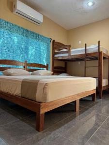 En eller flere senge i et værelse på Hotel Tunich Naj & Hostal