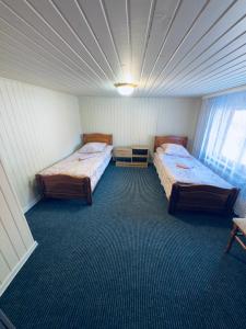 a room with two beds and a ceiling at Садиба у "Степана" in Synevyrsʼka Polyana