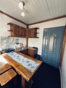 a kitchen with a wooden table and a blue door at Садиба у "Степана" in Synevyrsʼka Polyana