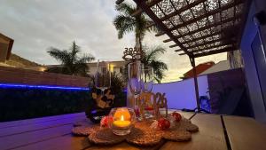 a table with two glasses and a candle on it at Palmview Private Pool in Arguineguín