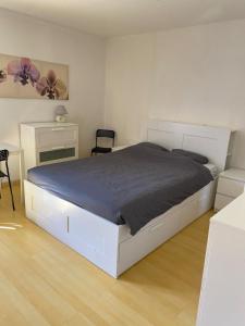 a bedroom with a large white bed and a table at La colonie in La Perrena