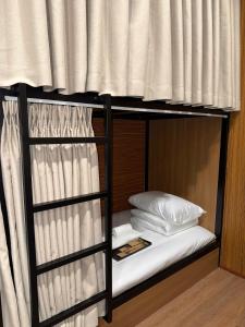 a bunk bed with white sheets and pillows on it at Peanut Stay Hostel in Hanoi