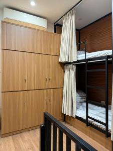 a bunk room with two bunk beds and wooden cabinets at Peanut Stay Hostel in Hanoi