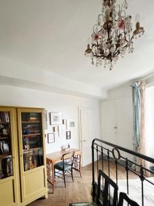 una camera da letto con un lampadario a braccio e un tavolo di Très bel appartement en plein centre d'Arbois ad Arbois