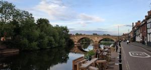 een brug over een rivier met bankjes op straat bij Central Bewdley - Load Street Retreat in Bewdley +10 foto's