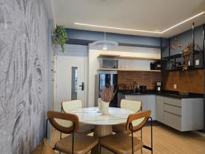 a kitchen and dining room with a table and chairs at Conforto e Lazer a 50m da Praia in Niterói