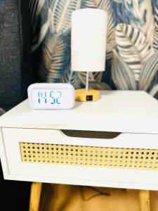 a table with a clock and a lamp on it at MOLA Apartments-Ruhrnahes Apartment mit Balkon & Parkplatz im Herzen von Schwerte-4P in Schwerte