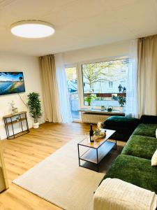 a living room with a green couch and a table at MOLA Apartments-Ruhrnahes Apartment mit Balkon & Parkplatz im Herzen von Schwerte-4P in Schwerte