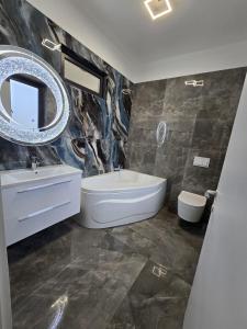 a bathroom with a tub and a sink and a mirror at Luxury Private Villa in Tunari