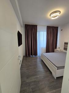 a bedroom with a bed and a large window at Luxury Private Villa in Tunari