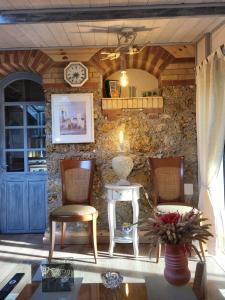 a room with two chairs and a table and a clock at La Garette in Elbeuf-sur-Andelle