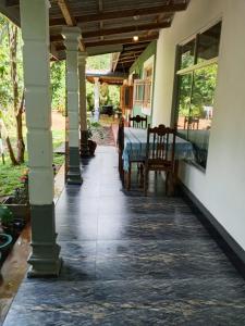 a porch of a house with a table and chairs at Thilina Homestay in Sigiriya